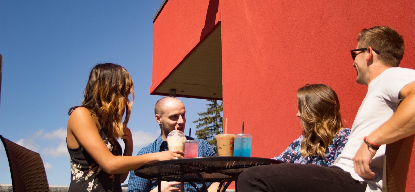 Friends with drinks at the patio table outside Winegar's